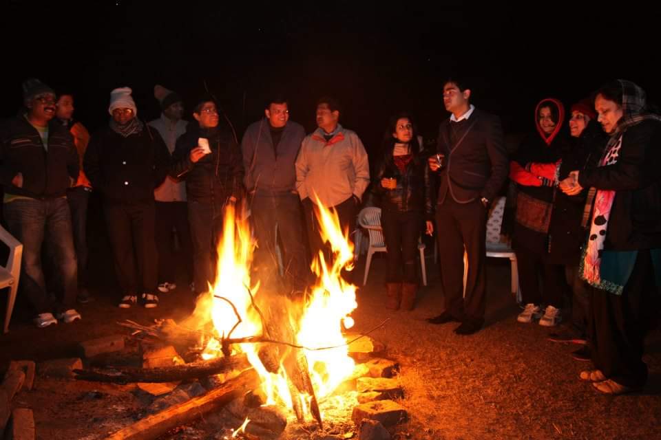 Employees gathered around a winter bonfire at a company outdoor celebration