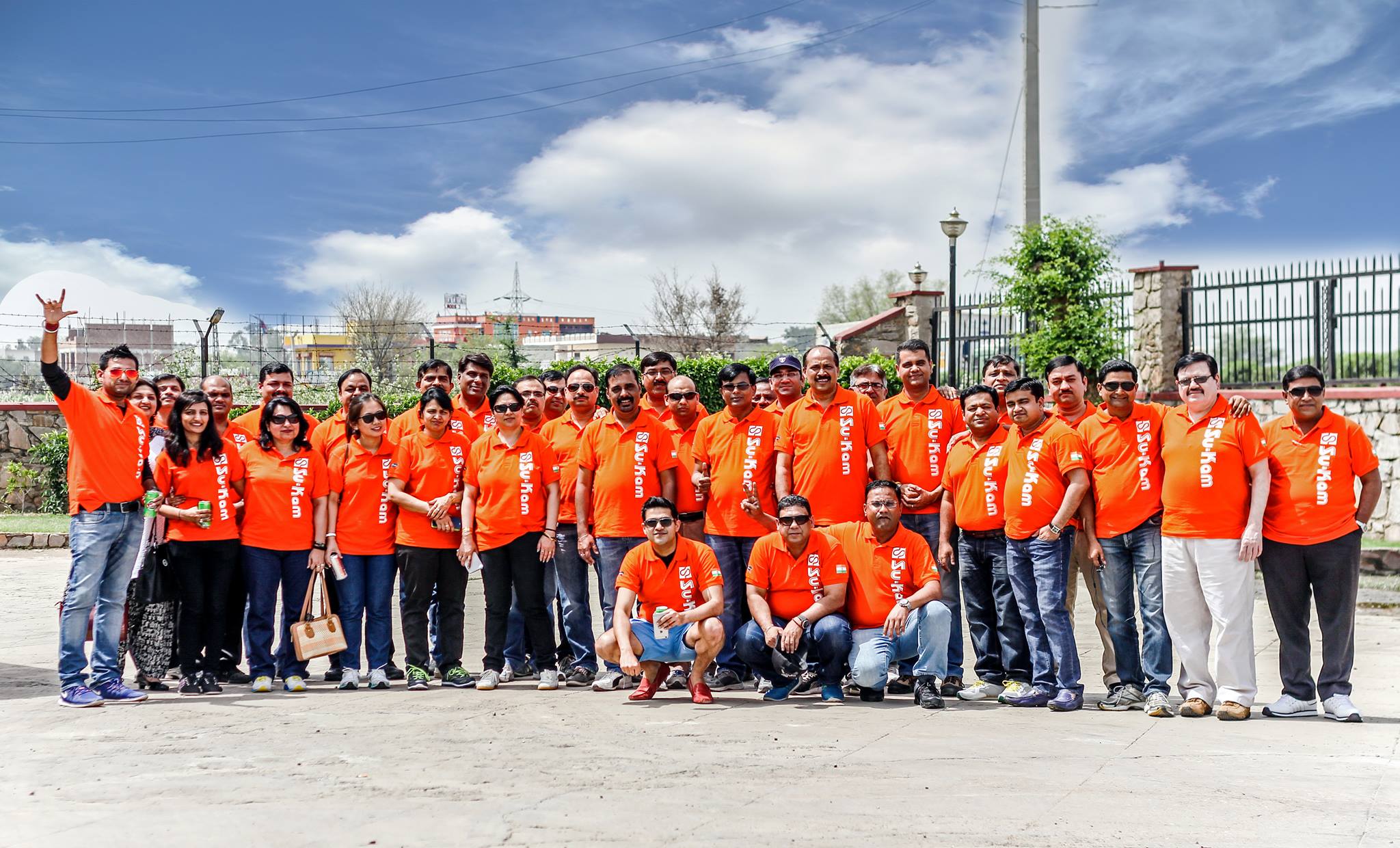 Su-Kam field team in matching orange branded polos at a Cluster Meet gathering