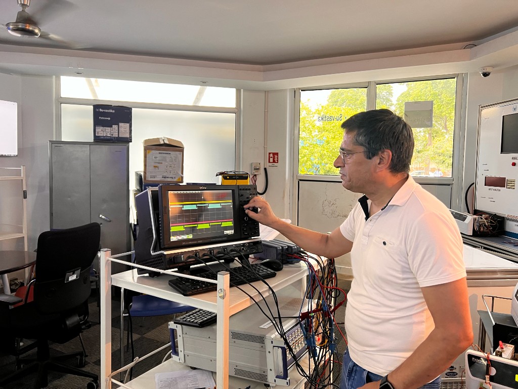 Engineer tuning a high-bandwidth LeCroy digital storage oscilloscope on the R&D cart