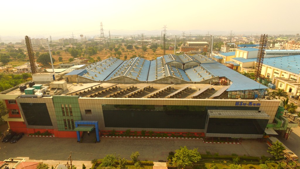 Aerial view of the Su-Kam manufacturing plant with north-light roof and branded facade