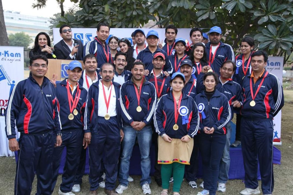 Su-Kam employees in matching tracksuits with medals at Sports Week 2012