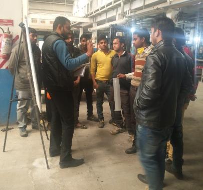 Acid-filling plant training with instructor and graduated cylinder
