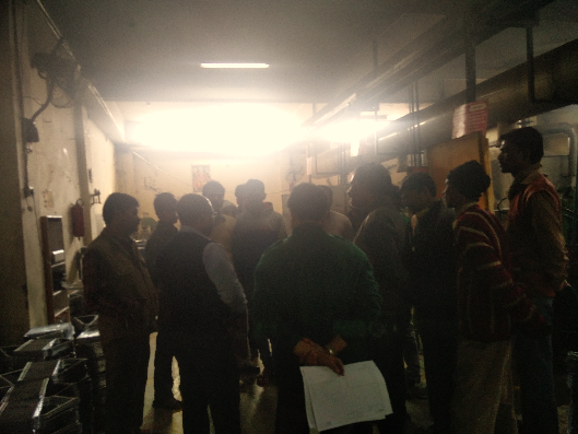 Su-Kam shop-floor plant training huddle beside battery grids