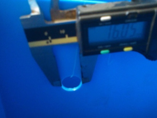Digital caliper measuring 16.05 mm intercell weld hole diameter on battery strap tooling