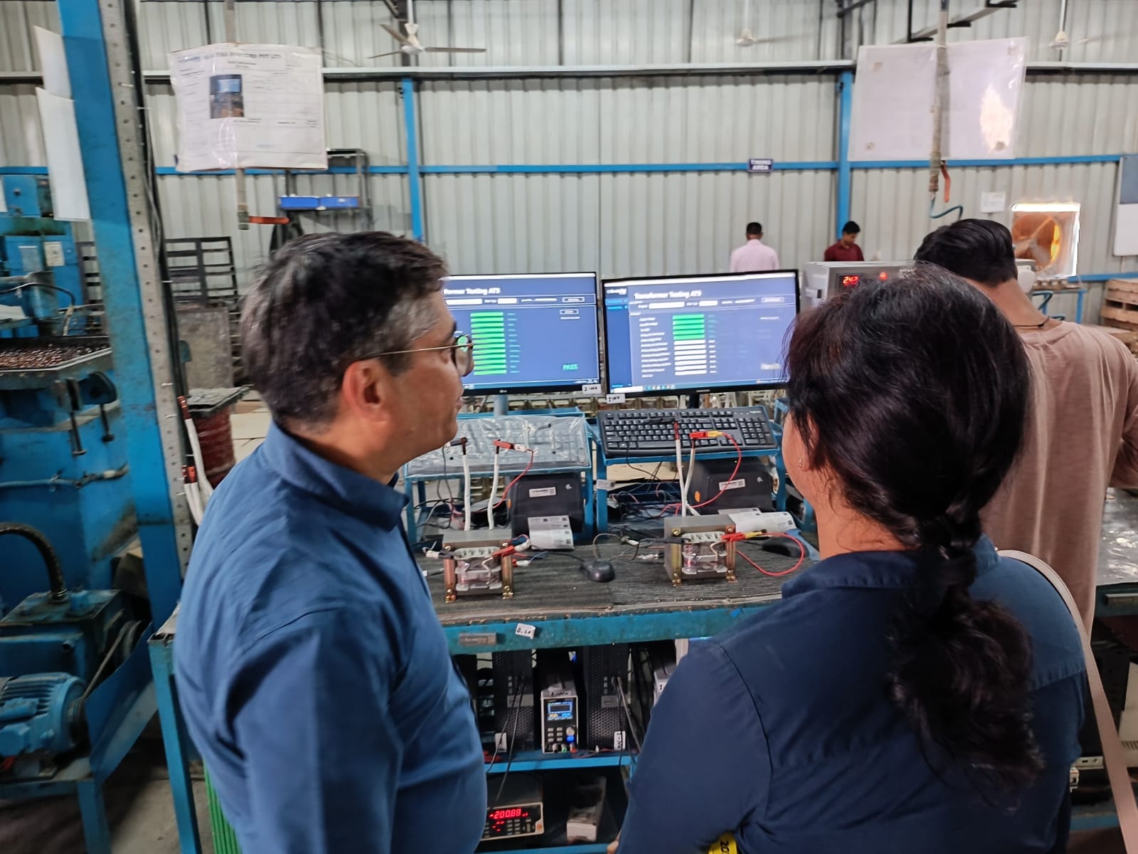 Factory floor transformer testing with ATS software screens showing PASS at Su-Vastika
