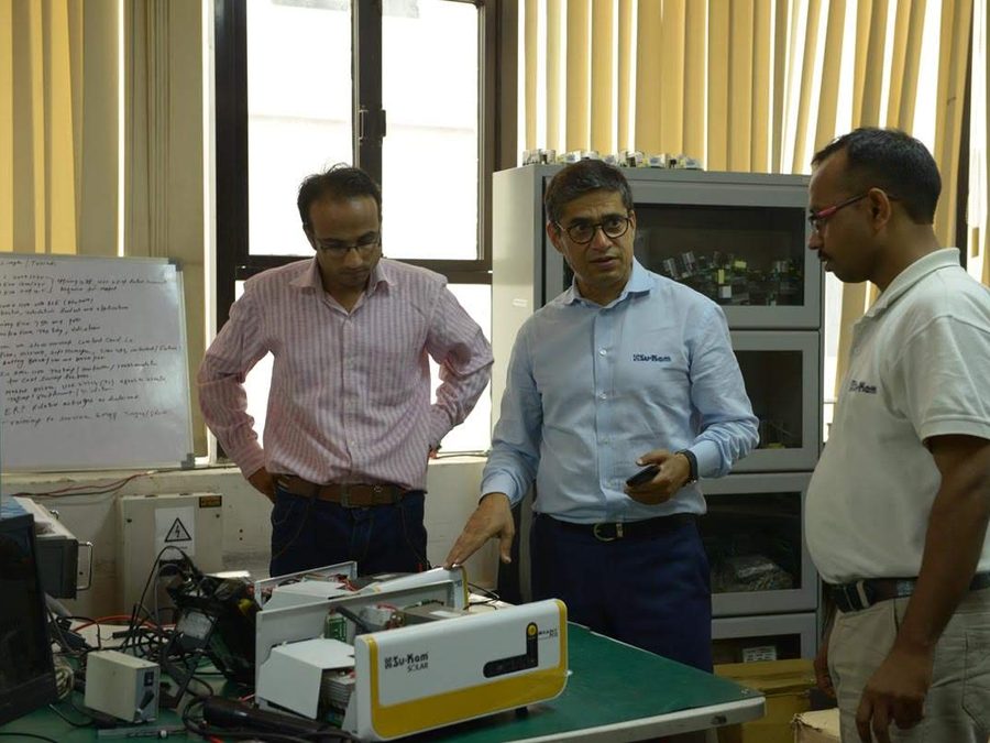 Kunwer with the R&D team reviewing power electronics on a workbench